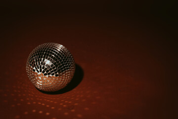 Glass disco ball isolated on dark brown background