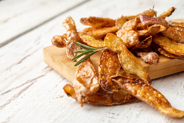 Fried potato peel on a white wooden table close-up.