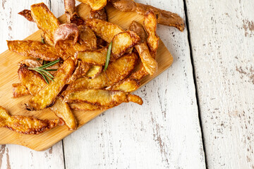 Potato peel chips on a white wooden table. Sustainable food. Selective focus.