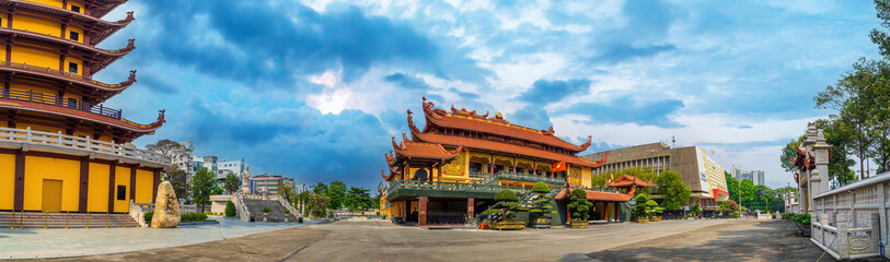 Fototapeta premium Quoc Tu Pagoda in Vietnam, Ho Chi Minh.Red tall asian temple on the blue sky background in Saigon. It is a famous pagoda in Ho Chi Minh city. Travel and religion concept.