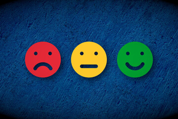 red angry yellow neutral and green happy faces over blue concrete wall, customer rating or feedback...