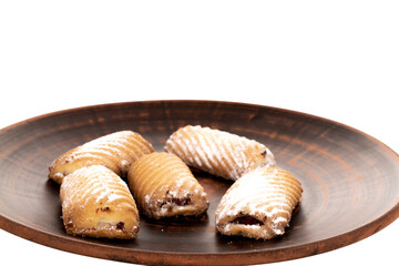 Several homemade cookies with jam on a plate of clay, close-up, isolated on white.
