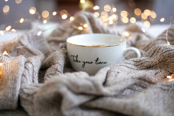 Take your time coffee mug in a sweater and string light bokeh