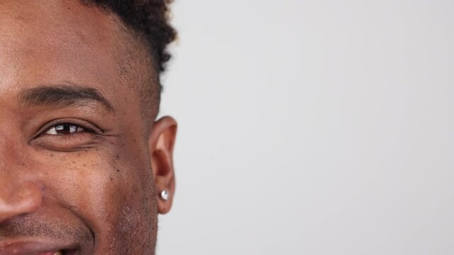 Close-up of a black man who looks into the camera with a happy look and smiles. A satisfied Afro guy enjoys good eyesight after a successful laser correction procedure, uses contact lenses.