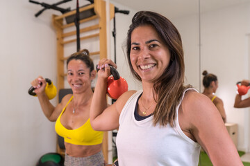 Latin girl doing sports in a session of physical therapy and sports osteopathy, instructor giving instructions to the client, weight exercises