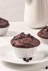 Chocolate muffins and carafe on the white surface. - 476912138