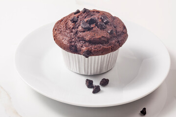 Chocolate muffin on the white dish. - 476912143