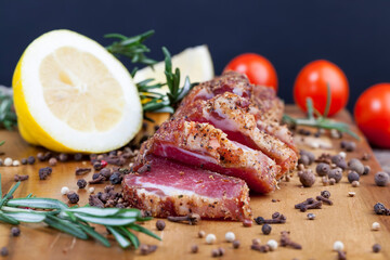 dried and spiced meat sliced on a wooden board