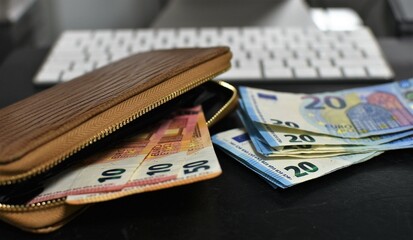 wallet with euro banknotes, keyboard for a computer
