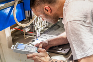 Worker technician engineer programming soft PVC dispensing machine in factory