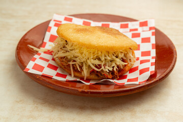 Latin American food Venezuelan arepa Peluda, shredded meat with yellow cheese