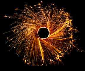 Night fire dance. Sparks from steel wool on a black background. Close-up.