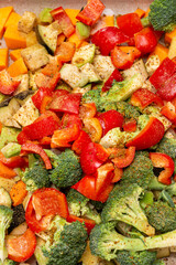 An original background of finely chopped and seasoned vegetables before baking in the oven. Potatoes, bell peppers, squash, pumpkin and broccoli. Healthy food close-up