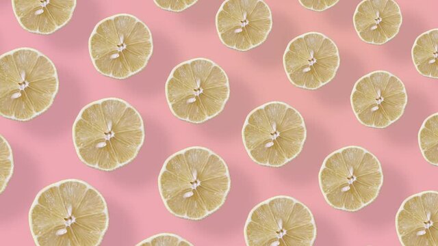 Colorful fruit pattern of fresh lemons on pink background with shadows. Seamless pattern with lemon slices. Realistic animation. 4K video motion
