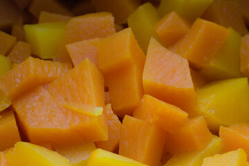 Slices of raw pumpkin with orange-yellow flesh. Autumn vegetarian cooking.