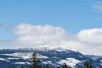 huge mountains covered by snow and sunny sky with clouds british columbia canada