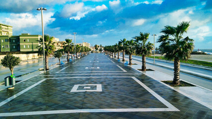 Aerial view of city promenade along the ocean, beautiful coast at sunset from drone.