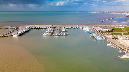 Fishing boats in a small port, aerial overhead view from drone.