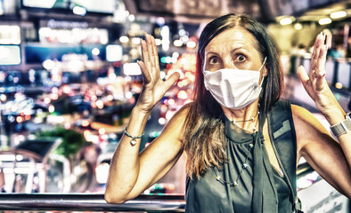 Terrified woman in the city traffic wearing breathing mask for pollution and coronavirus