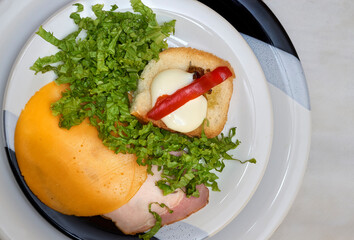 food plate seen from above with cold cuts, cheese, lettuce and toast with cheese and bell pepper