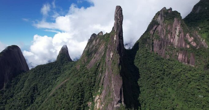 Wide view aerial panoramic landscape of Brazil mountain range Serra dos Orgaos in Teresopolis, Rio de Janeiro with Dedo de Deus, Gods finger, peak in the middle and clouds behind