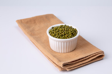 mung bean in white bowl on cloth and white background studio shot