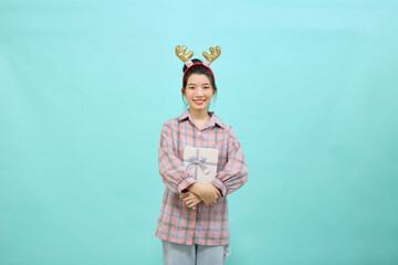 Woman is wearing Christmas reindeer holding gift box