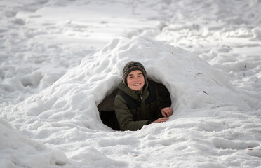 Boy playing in snow dome on mountain
