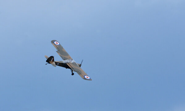Vintage  Auster AOP6 TW536 Aeroplane in flight against blue sky.