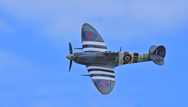 ICKWELL, BEDFORDSHIRE, ENGLAND - SEPTEMBER 06, 2020: Vintage  Supermarine Spitfire Mk Vb AB910 in flight  against blue sky.