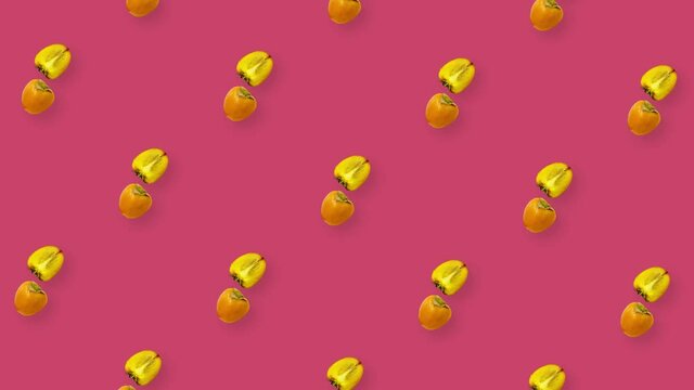 Colorful pattern of fresh orange persimmons on pink background. Top view. Seamless pattern with persimmon sliced. Pop art design. Realistic animation. 4K video motion