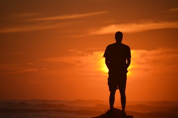 Horizontale Shadow of man enjoy sunset over the sea, silhouette of a person