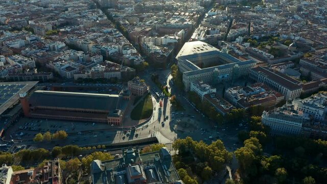 Amazing aerial view of heavy traffic on roads and various buildings around Atocha train station in late afternoon sunshine.