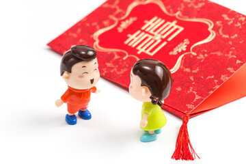 Two dolls in front of a wedding invitation