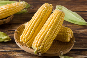 fresh raw corn cobs on wooden table
