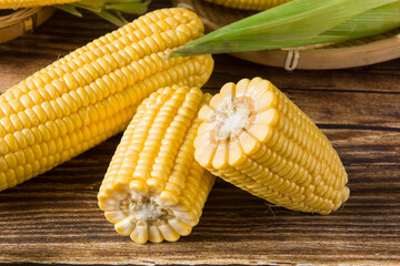 fresh raw corn cobs on wooden table