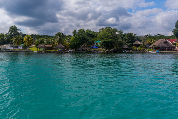 Palms and houses on the lagoon, Laguna Bacalar, Chetumal, Quintana Roo, Mexico.
