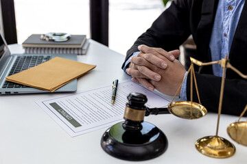 A male lawyer sits in his office, on a table with a small hammer to beat the judge's desk in court....