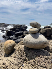 Fototapeta na wymiar Calming stacked rocks on a beach at Cathedral Rocks, Kiama, New South Wales, Australia