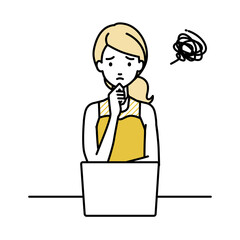 デスクで座ってPCを開いて困っているドレスの女性