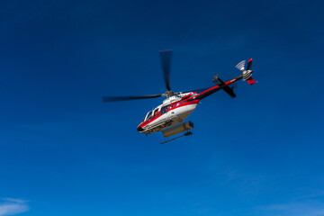 Fototapeta na wymiar Helicopter Flying in Clear Blue Sky