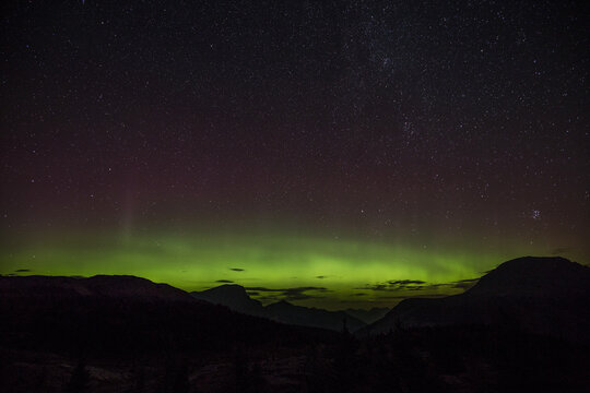 A beautiful green and red aurora dancing in Sunshine Village, Canada