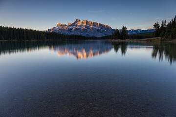 Fototapeta na wymiar Rundle Mountain reflecting in Two Jack Lake in Banff National Park at sunrise.