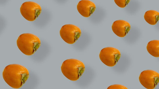 Colorful pattern of fresh orange persimmons. Seamless pattern with persimmon. Pop art design. Realistic animation. 4K video motion