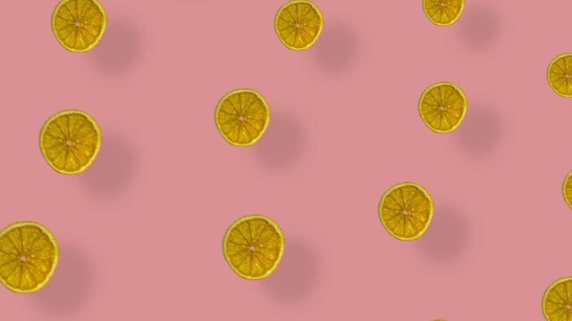 Colorful pattern of dried orange slices on pink background with shadows. Seamless pattern with dried orange chips. Realistic animation. 4K video motion