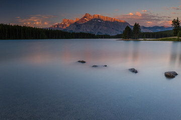 Rundle Mountain reflecting in Two Jack Lake in Banff National Park at sunrise.