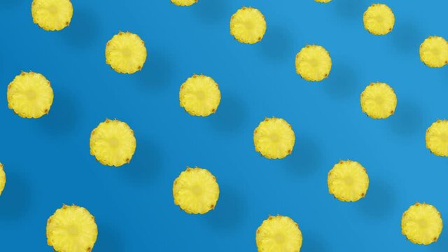 Colorful fruit pattern of fresh pineapple on blue background with shadows. Seamless pattern with pineapple sliced. Realistic animation. 4K video motion