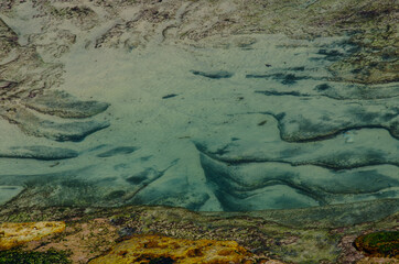 Beautiful abstract patterns on the sand at rocky beach.
