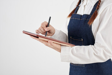 Cropped image of waitress in denim apron checking menu on tablet computer