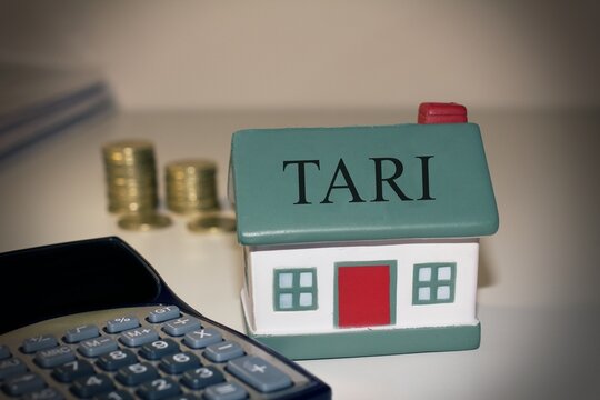 House with a calculatore and euro coins with the text "Tari" concept of italian tax